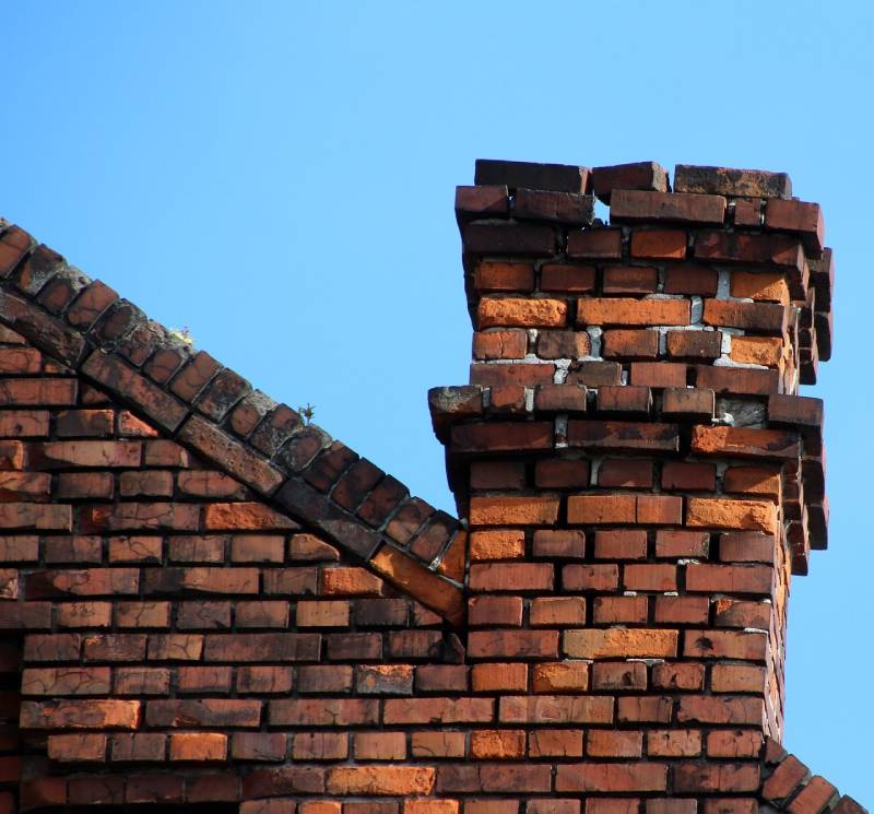 Damaged chimney on an Elgin home showing cracks and missing mortar